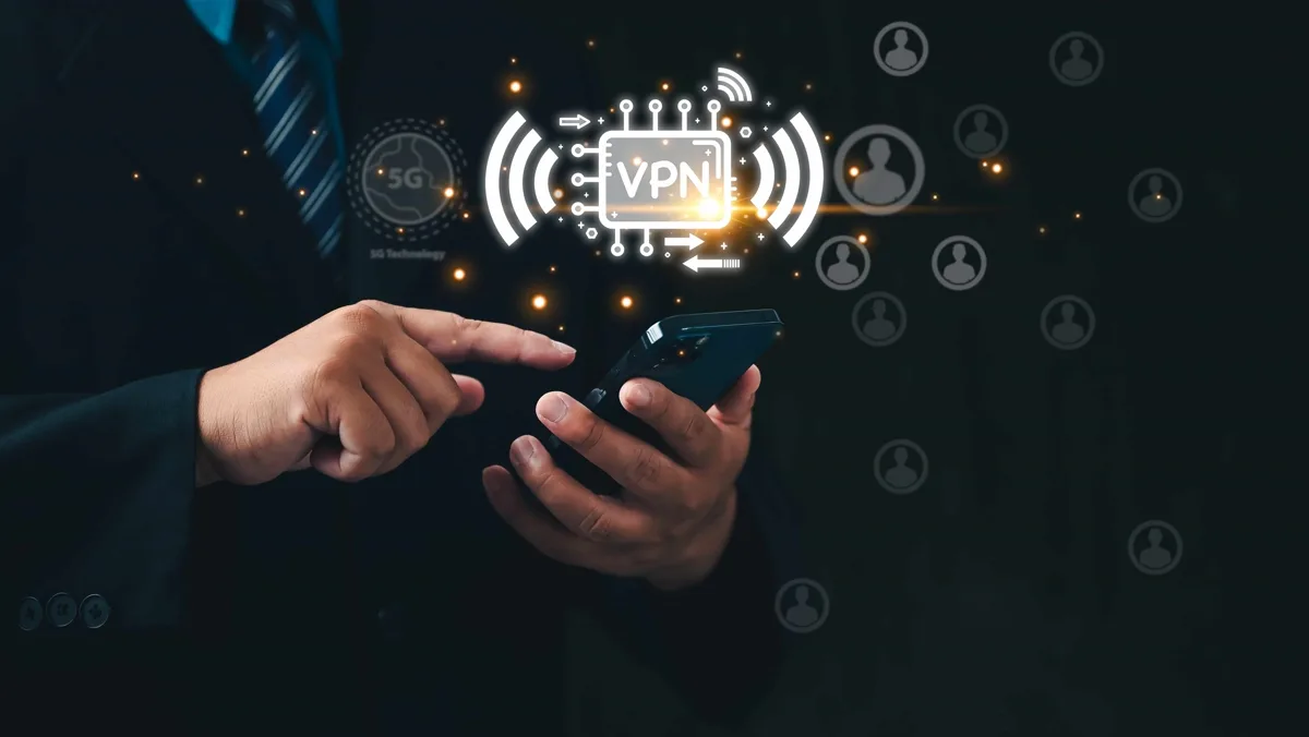 Man uses smartphone with VPN icon on virtual screen.